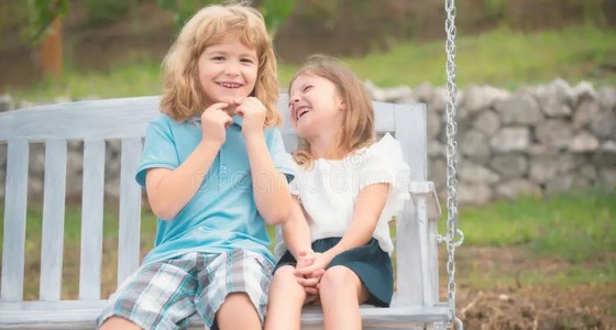 Two children smiling together, representing communication confidence for students